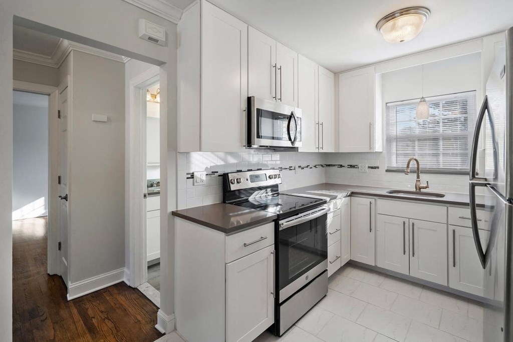 A kitchen with white cabinets and stainless steel appliances.