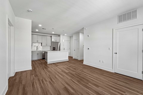 A kitchen with white cabinets and a wooden floor.