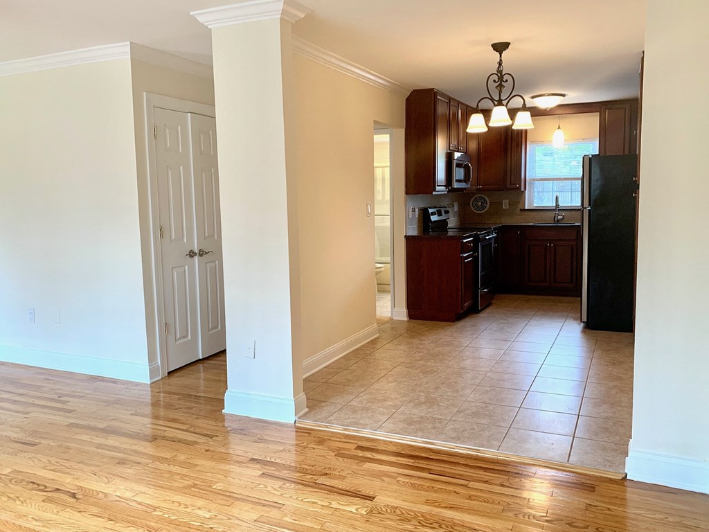 an empty kitchen and living room with a wood floor