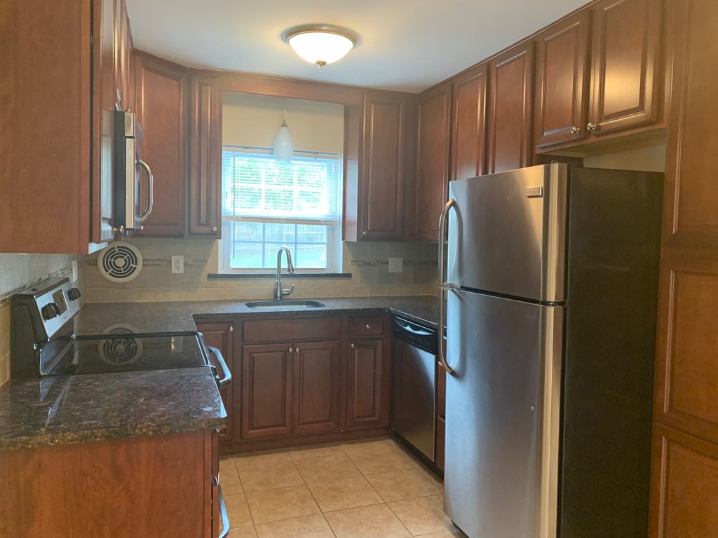 a kitchen with stainless steel appliances and wooden cabinets