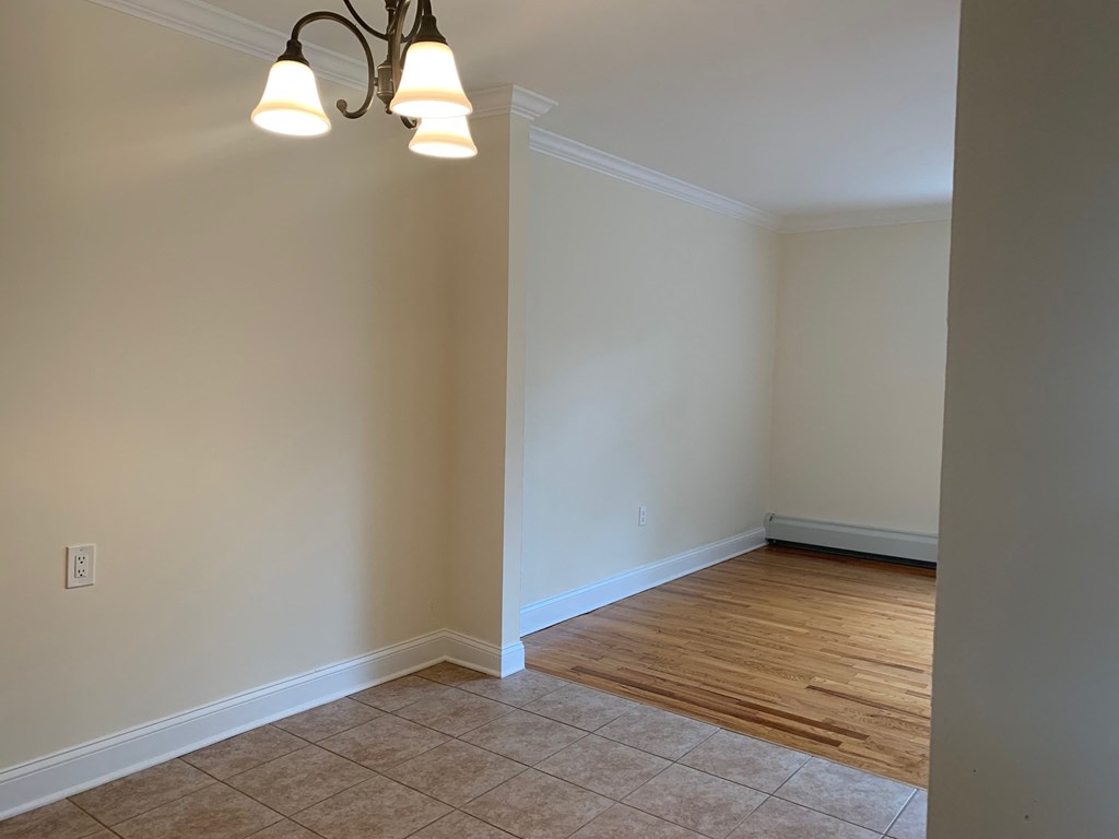 a empty living room with a wooden floor and white walls