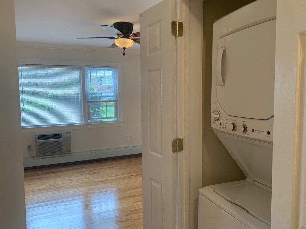 an empty laundry room with a washer and dryer and a ceiling fan