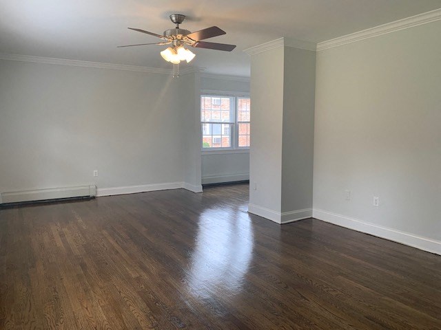 an empty living room with a ceiling fan and a window