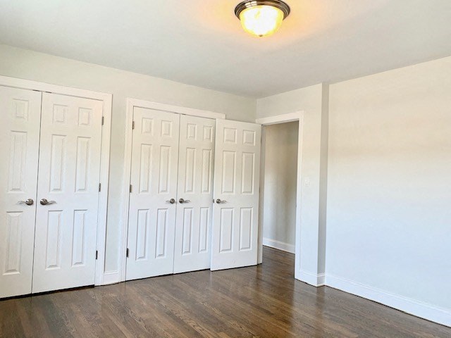 an empty room with three closets and a light on the ceiling