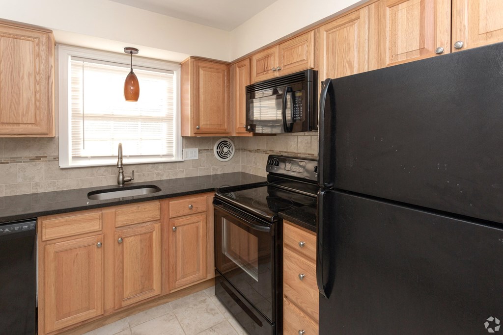 a kitchen with black appliances and wooden cabinets