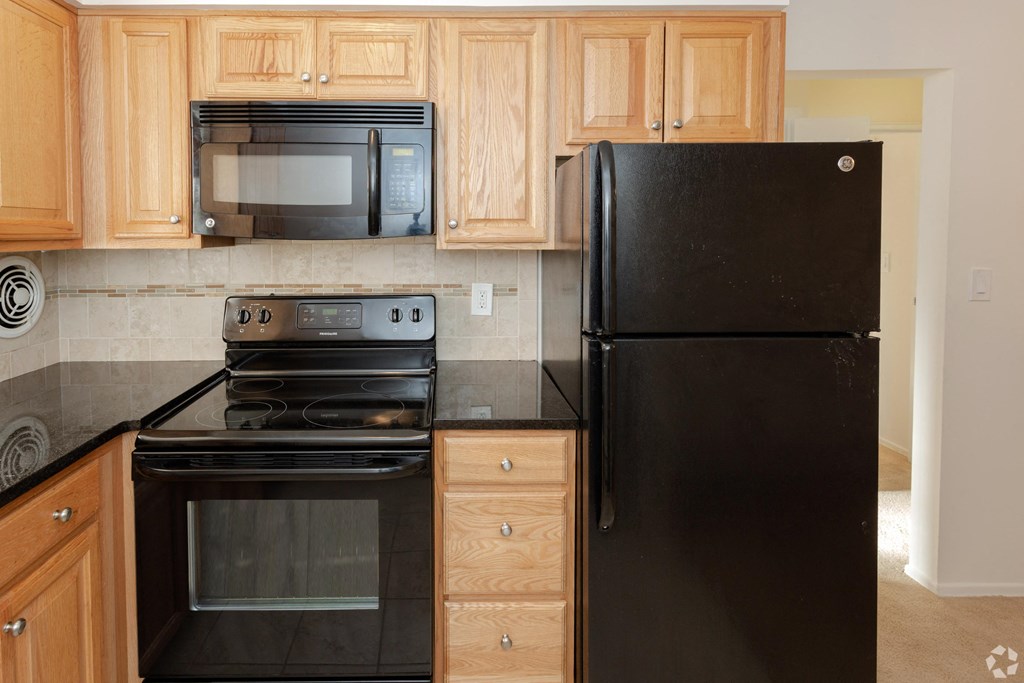 a kitchen with black appliances and wood cabinets