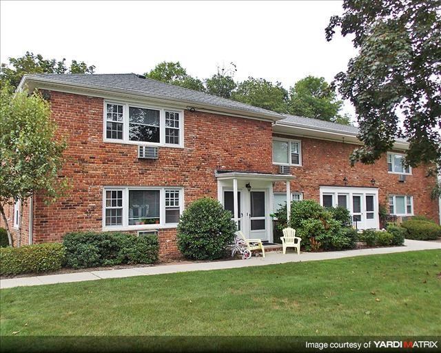 a red brick house with white windows and a lawn