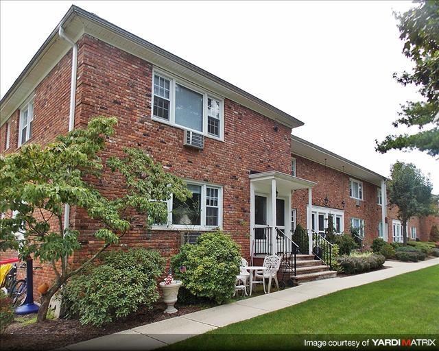 a red brick house with a porch and a lawn
