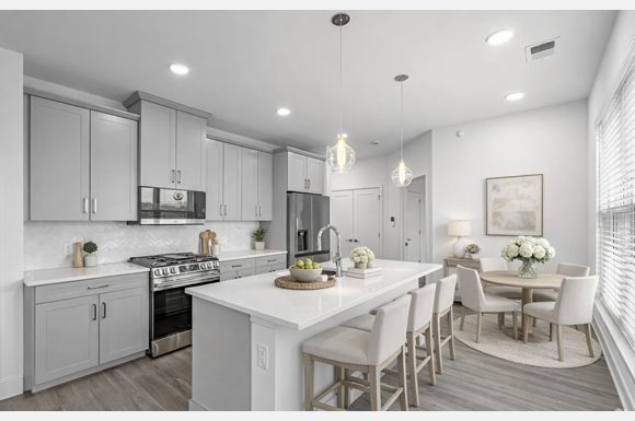 A modern kitchen with a dining table set for two.