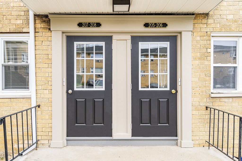 a pair of black doors on a brick building