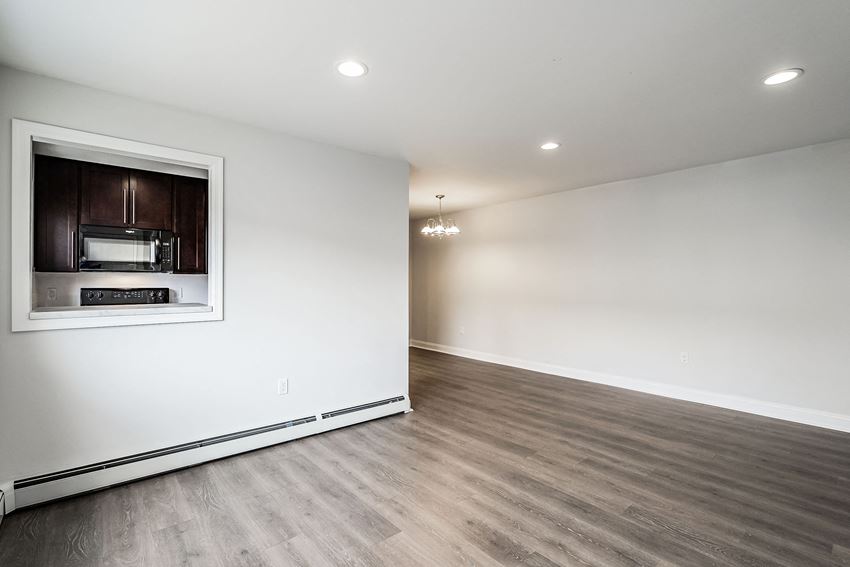 a living room with white walls and a window with a microwave in it