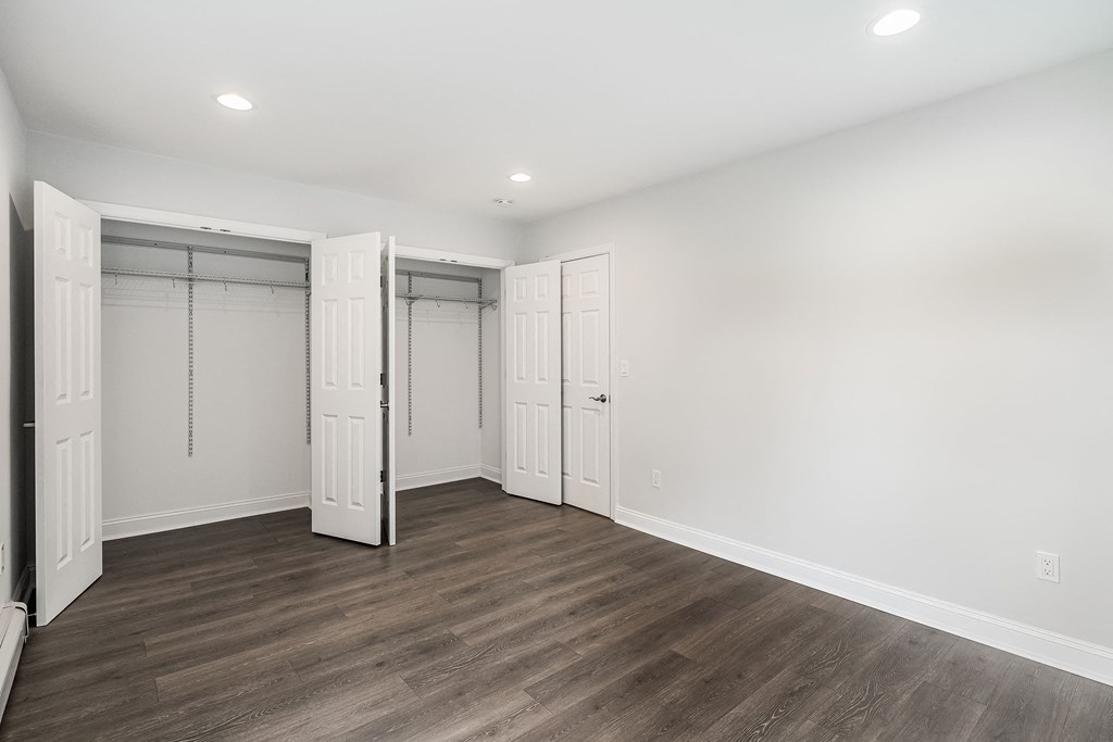 a bedroom with white walls and white closet doors