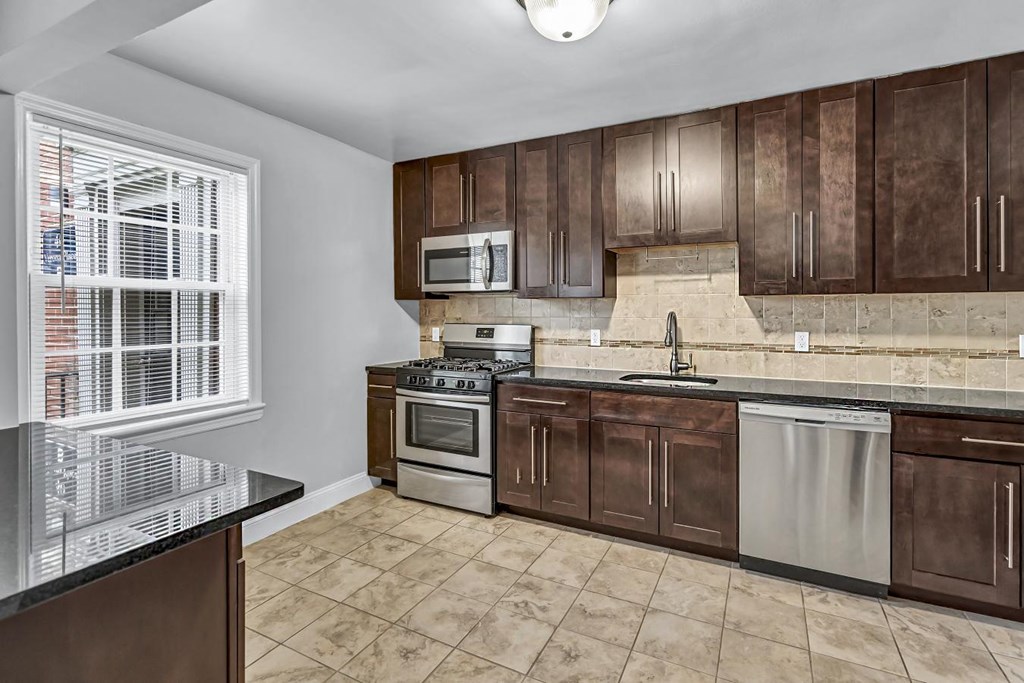 a kitchen with wooden cabinets and stainless steel appliances