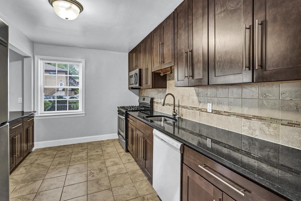 a kitchen with wooden cabinets and a window