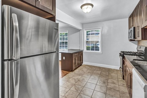 a kitchen with a stainless steel refrigerator and a window