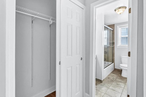 a bathroom with a closet and a toilet and a shower