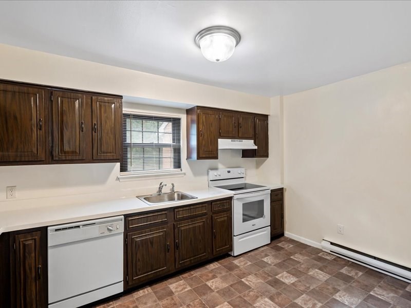 a kitchen with white appliances and wooden cabinets