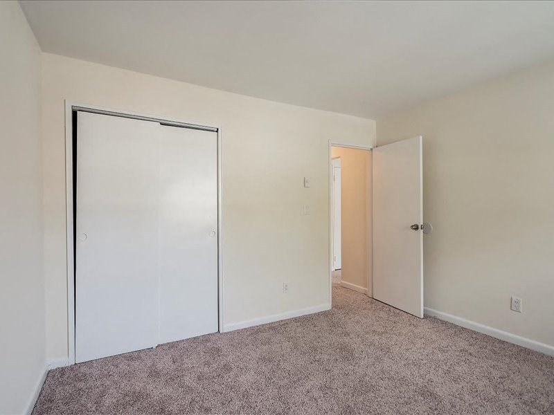 an empty bedroom with white walls and a closet