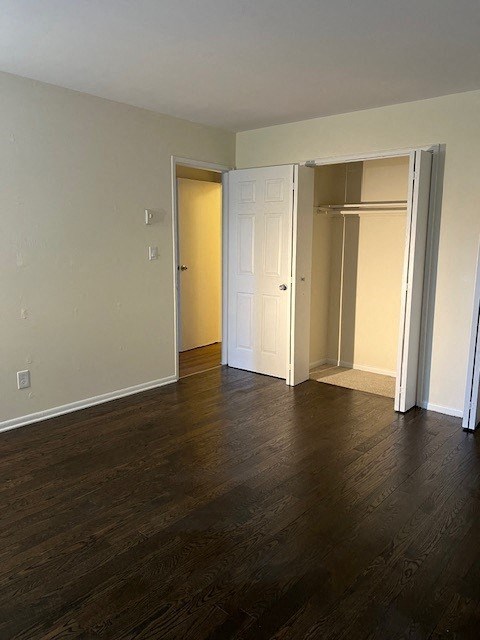 an empty living room with wood floors and a closet