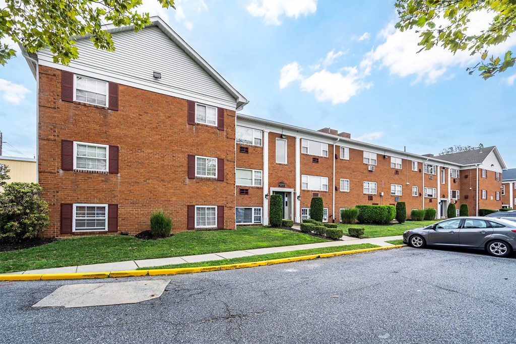 a brick apartment building with a parking lot