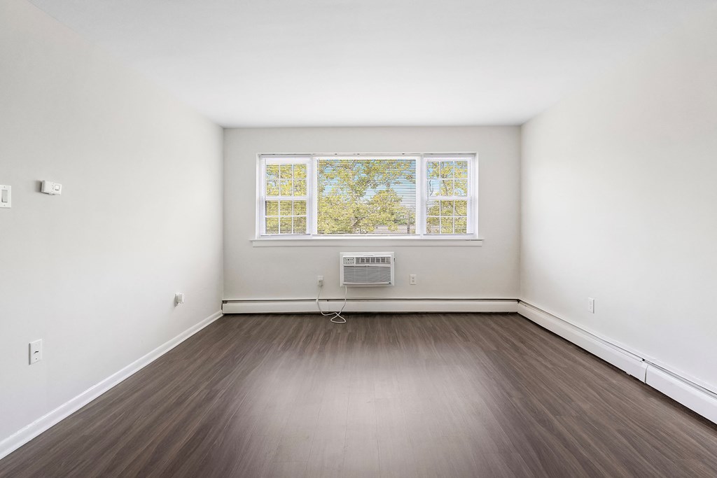 an empty room with wood floors and a window