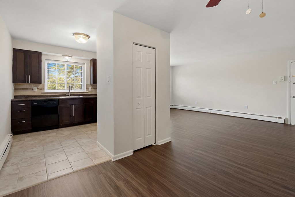 an empty kitchen and living room with wood floors and white walls