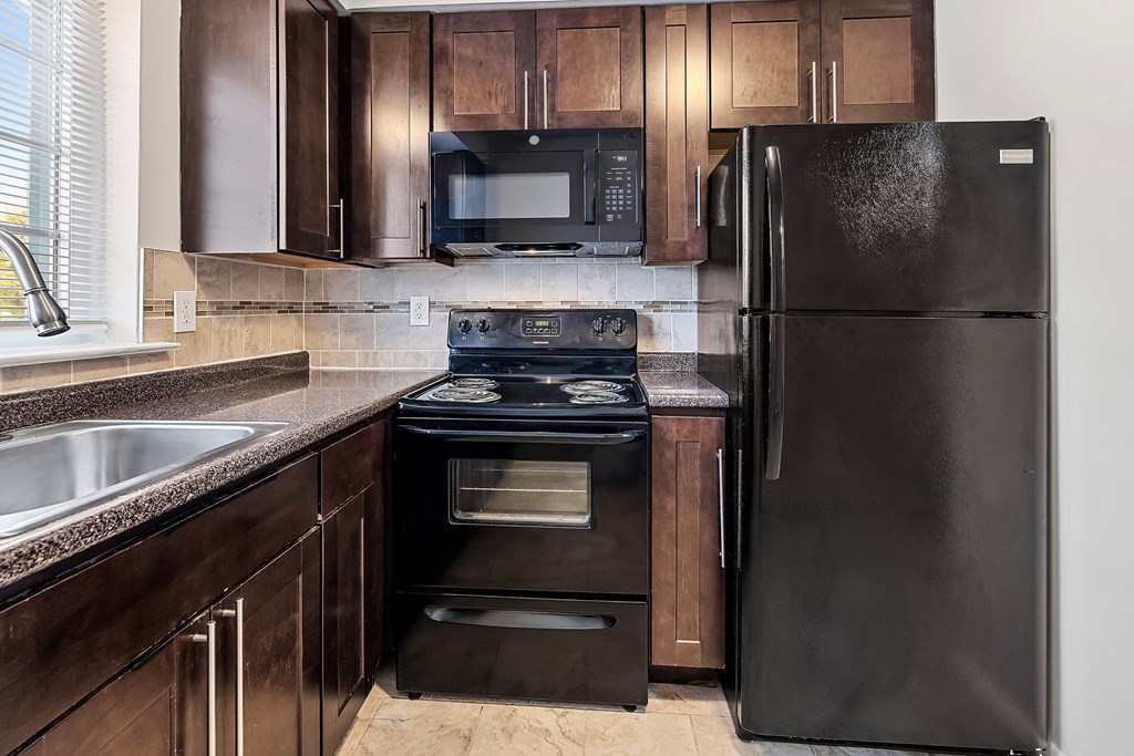 a kitchen with black appliances and wooden cabinets