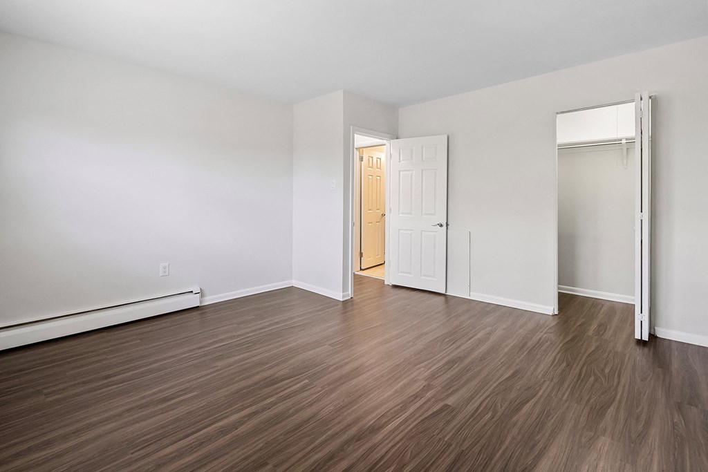 an empty living room with wood flooring and white walls
