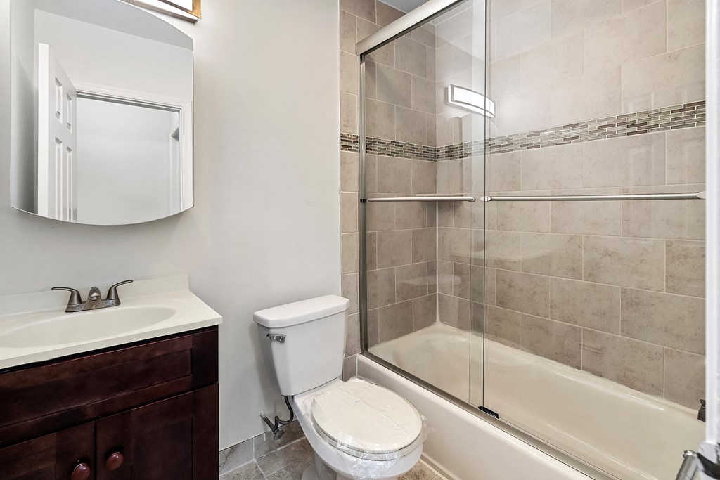 a bathroom with a shower toilet and sink