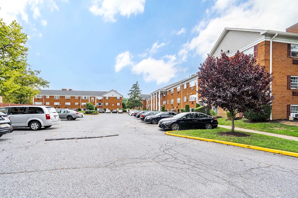 a parking lot with cars in front of a brick building