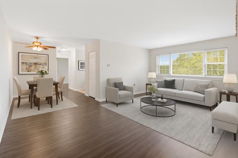 A living room with a white couch, a coffee table, and a dining table with chairs.