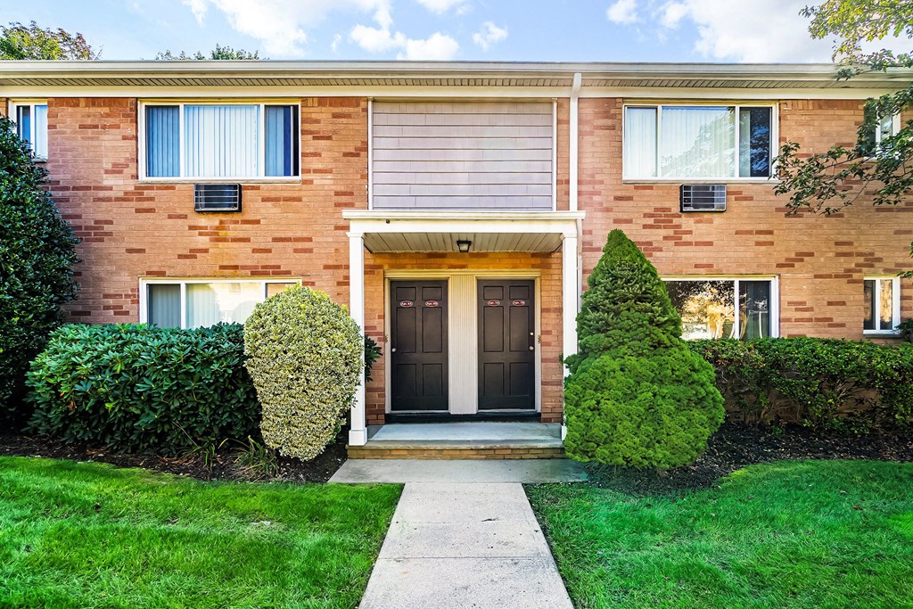 the front of a brick house with a sidewalk in front of it