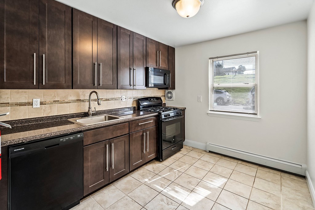 a kitchen with wooden cabinets and a sink and a window