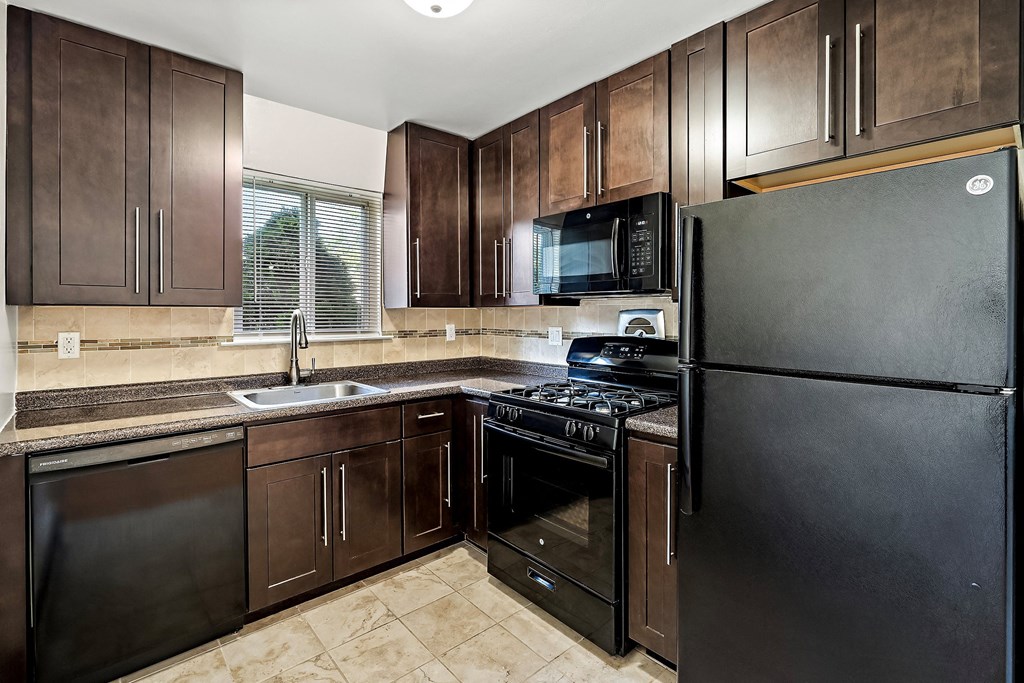 a kitchen with black appliances and wooden cabinets