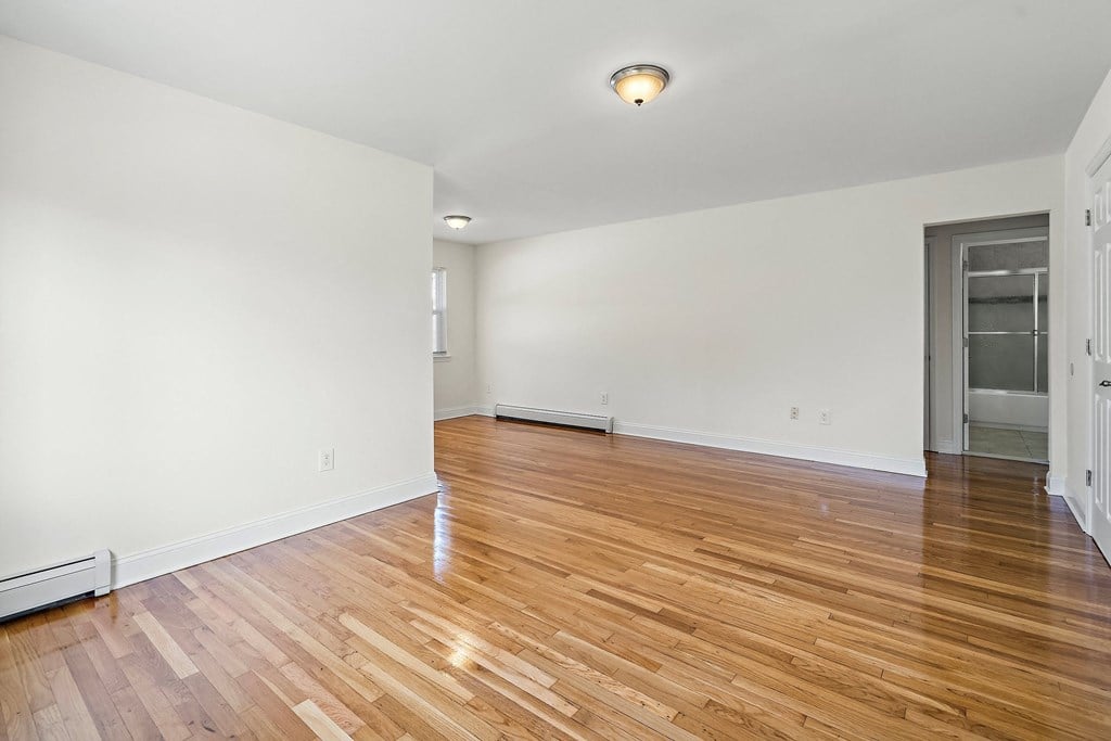 a living room with a hardwood floor and white walls