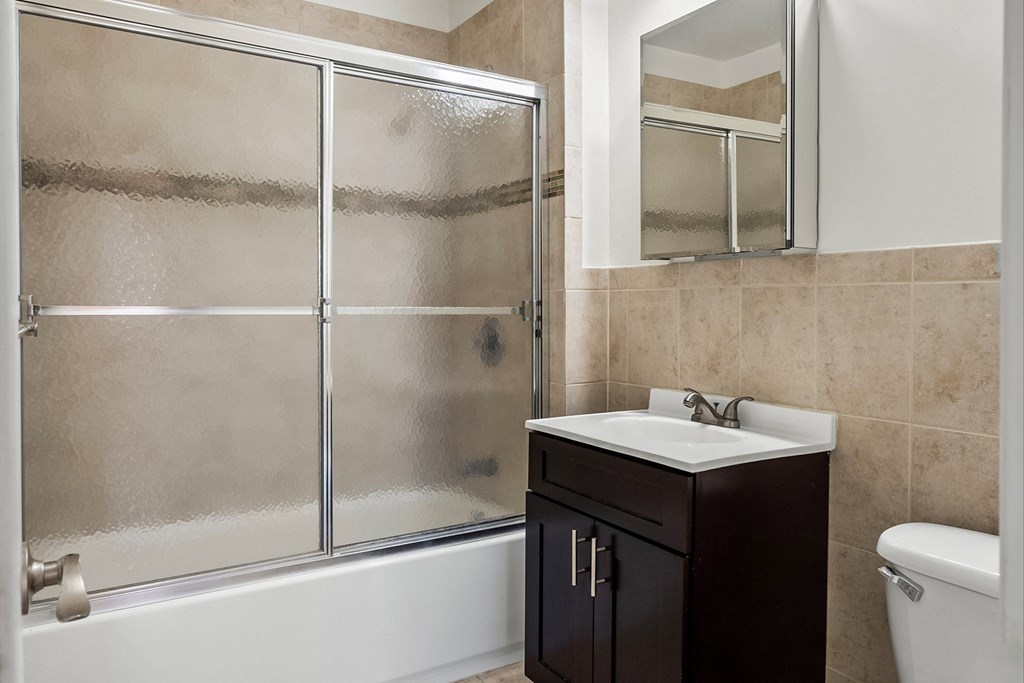 a bathroom with a shower and a sink and a toilet