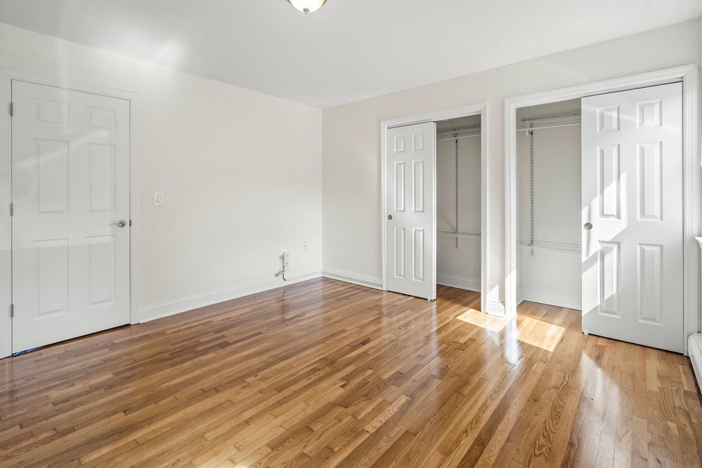 a living room with white doors and a wood floor