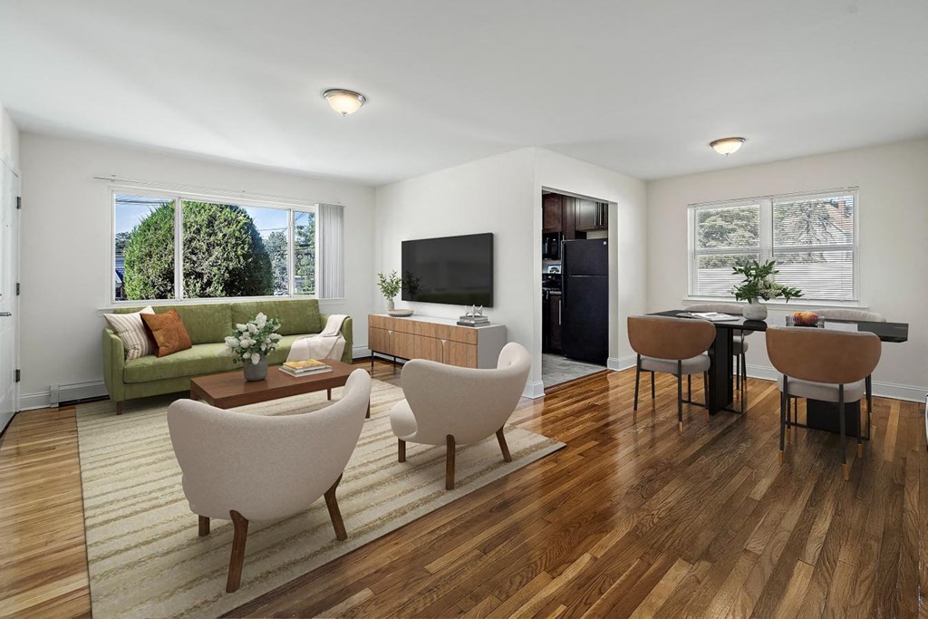 A living room with a green couch, a coffee table, and a television.