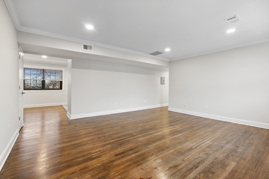 an empty living room with wood floors and white walls