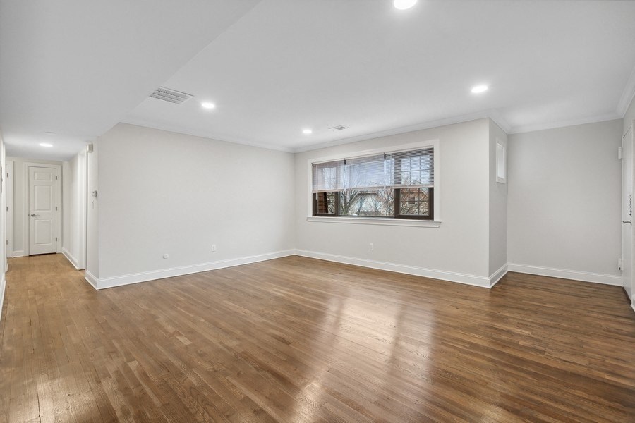 an empty living room with white walls and wood floors