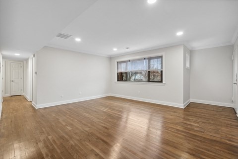 an empty living room with white walls and wood floors