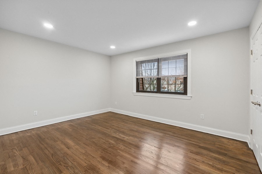 an empty living room with wood floors and a window