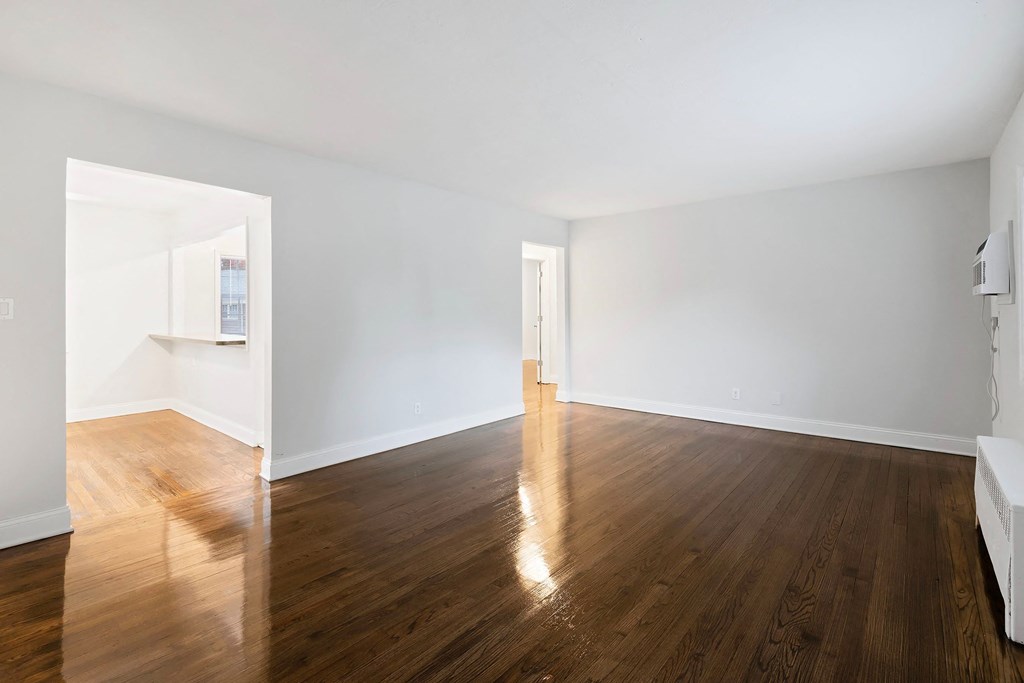 an empty living room with white walls and wood floors