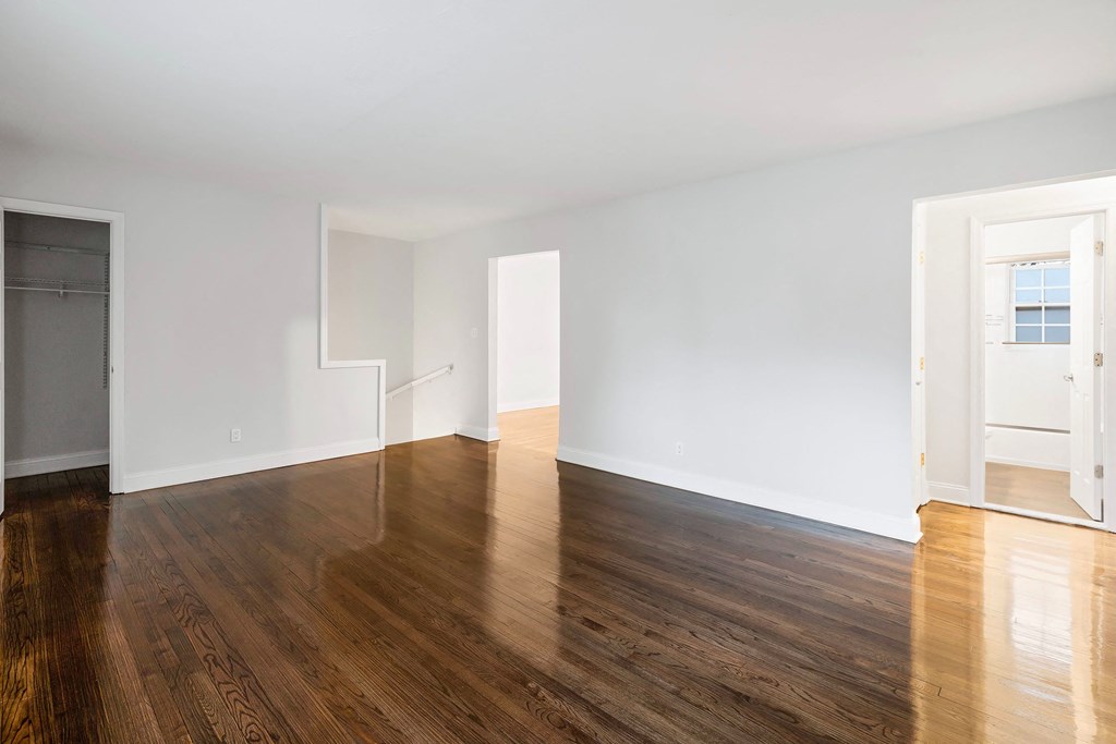 a living room with a hard wood floor and white walls