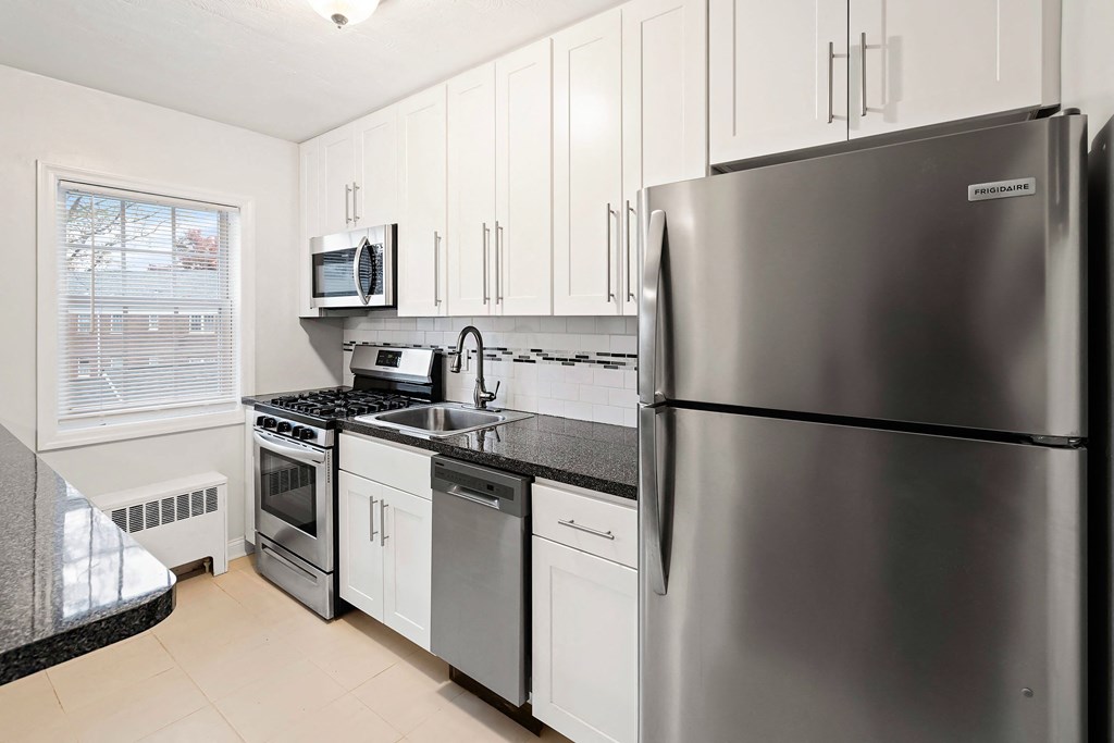 a kitchen with stainless steel appliances and white cabinets