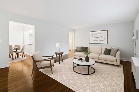 A living room with a white couch, a coffee table, and a rug.