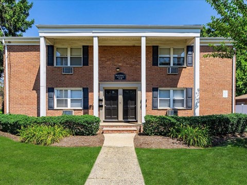a brick house with a sidewalk in front of it