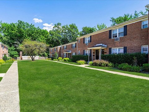 a green lawn in front of a brick apartment building