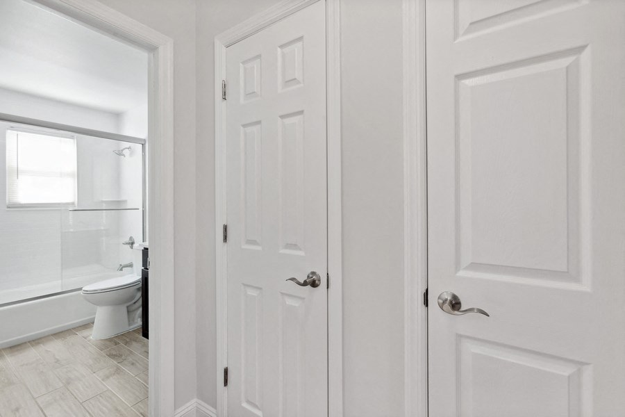 a white door leading into a bathroom with a toilet