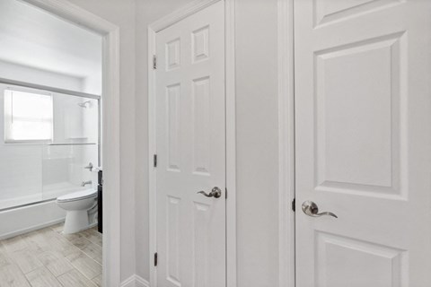 a white door leading into a bathroom with a toilet